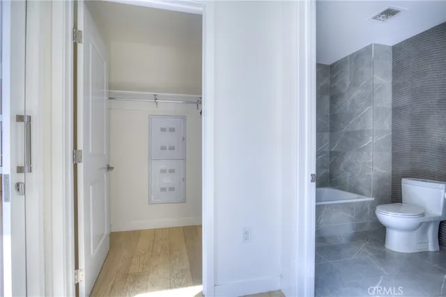a bathroom with a granite countertop bathtub sink vanity mirror and toilet