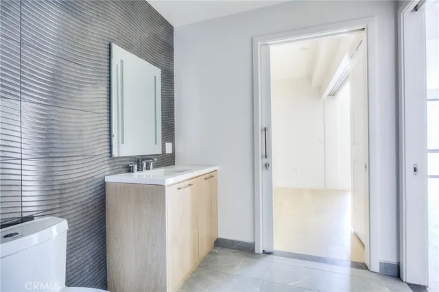 a bathroom with a granite countertop bathtub sink vanity mirror and toilet