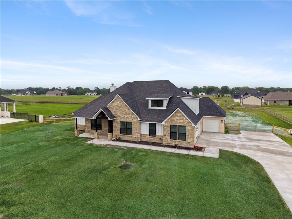 7822 Mathis Crk Drive Bryan, TX 77808 - Photo 42 of 43 a front view of a house with a garden and lake view