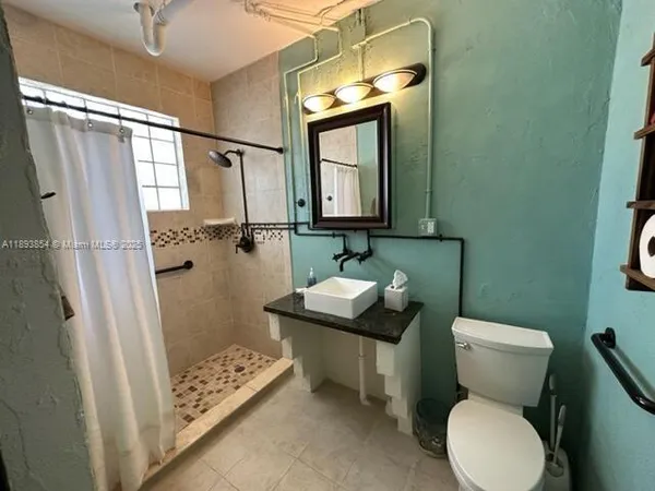 a bathroom with a toilet sink and mirror