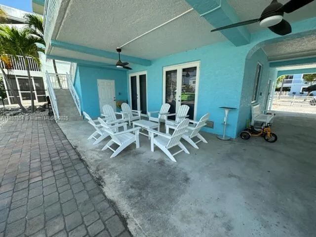 a view of a patio with table and chairs near a barbeque