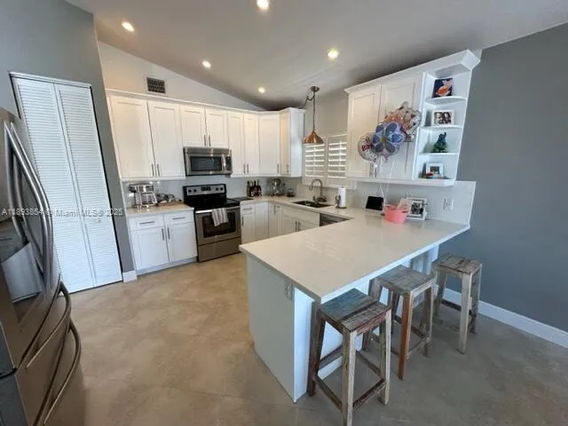 a kitchen with refrigerator cabinets and wooden floor