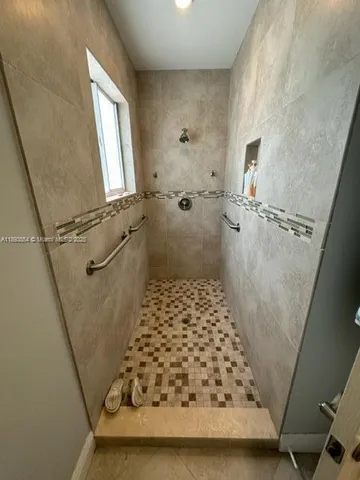 a bathroom with a sink a toilet a window and shower