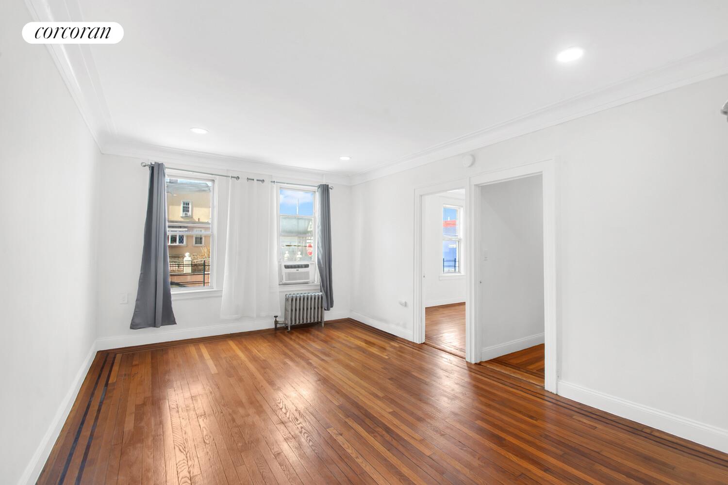 95-07 Cresskill Place Queens, NY 11435 - Photo 11 of 40 an empty room with wooden floor and windows