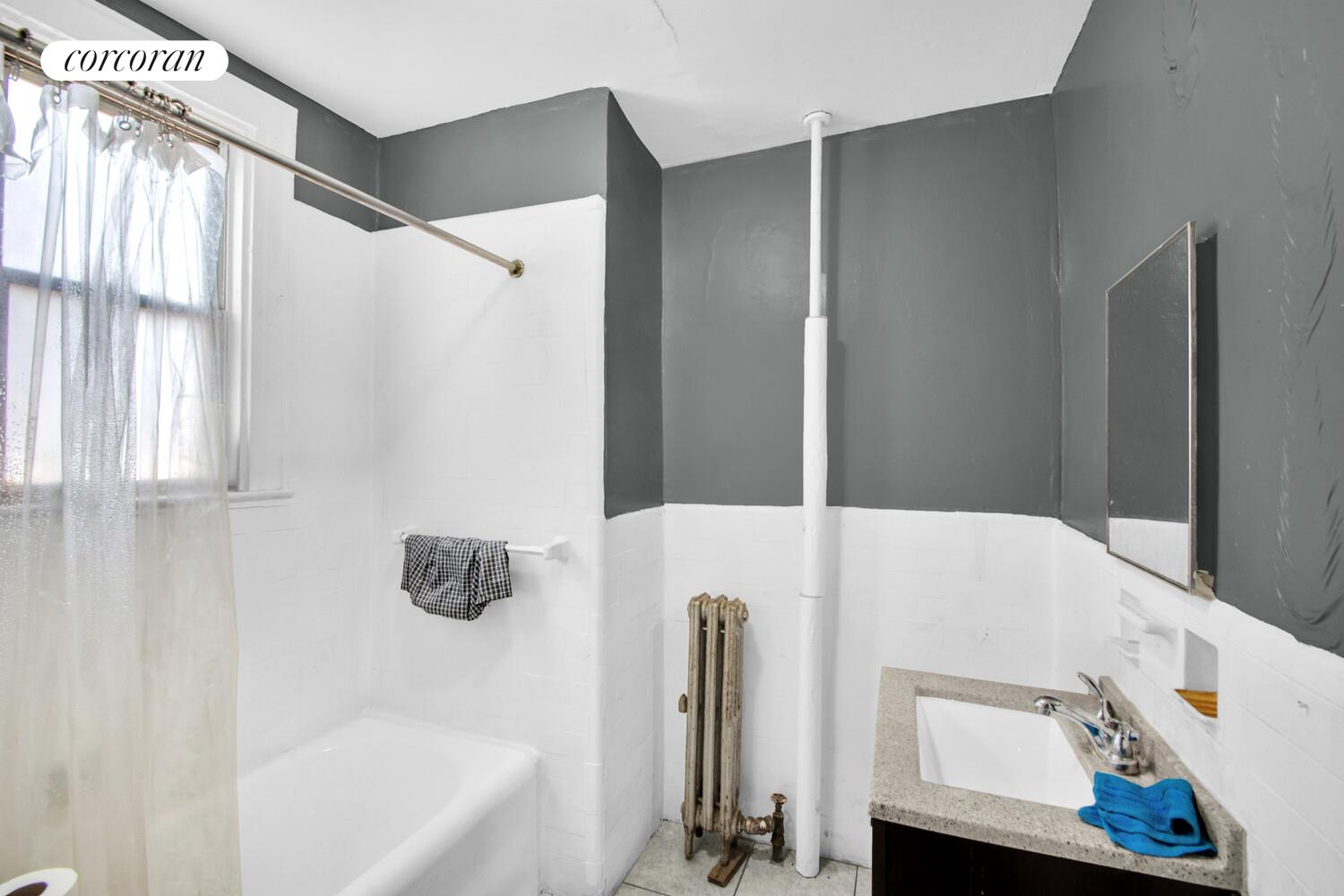 95-07 Cresskill Place Queens, NY 11435 - Photo 19 of 40 a bathroom with a bathtub and a window