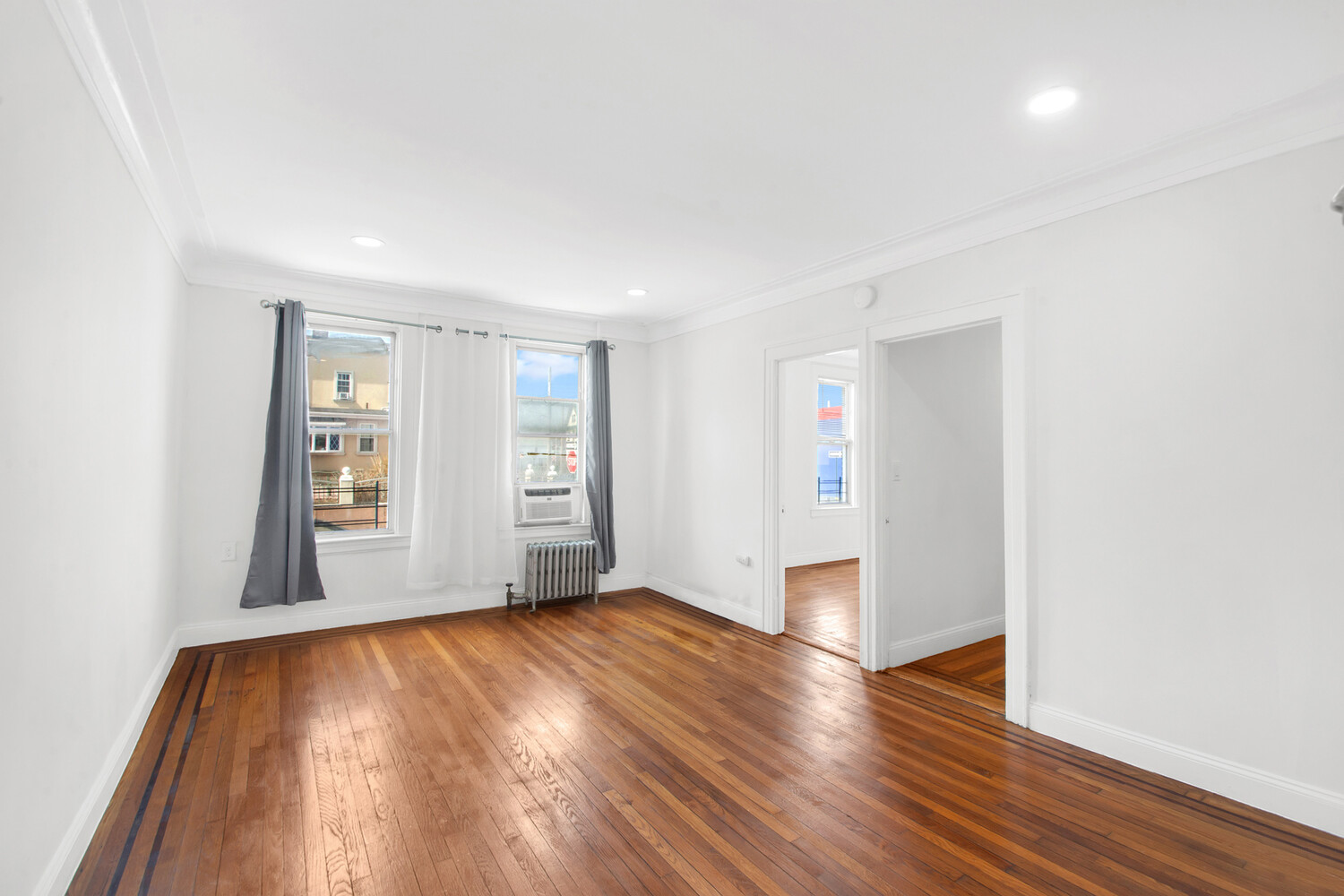 95-07 Cresskill Place Queens, NY 11435 - Photo 24 of 40 an empty room with wooden floor and windows