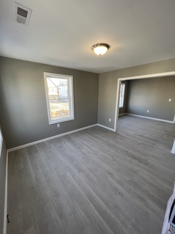 97 Alderman Street Springfield, MA 01108 - Photo 2 of 10 a view of an empty room with a window and wooden floor