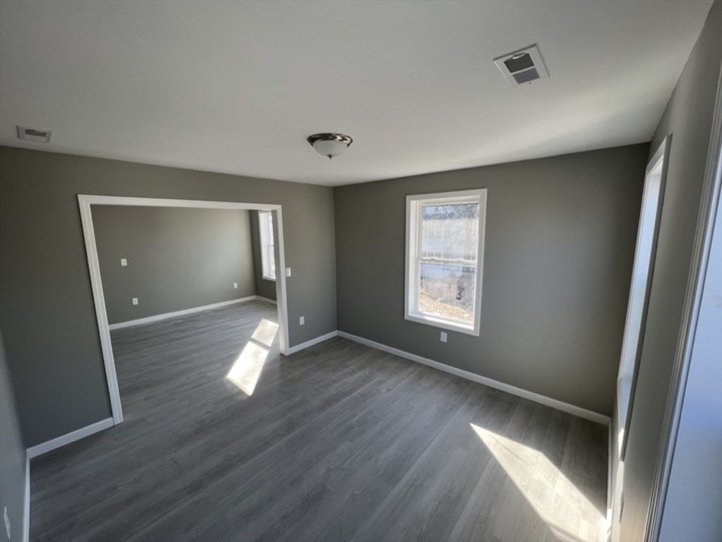 97 Alderman Street Springfield, MA 01108 - Photo 3 of 10 a view of empty room with wooden floor and fan