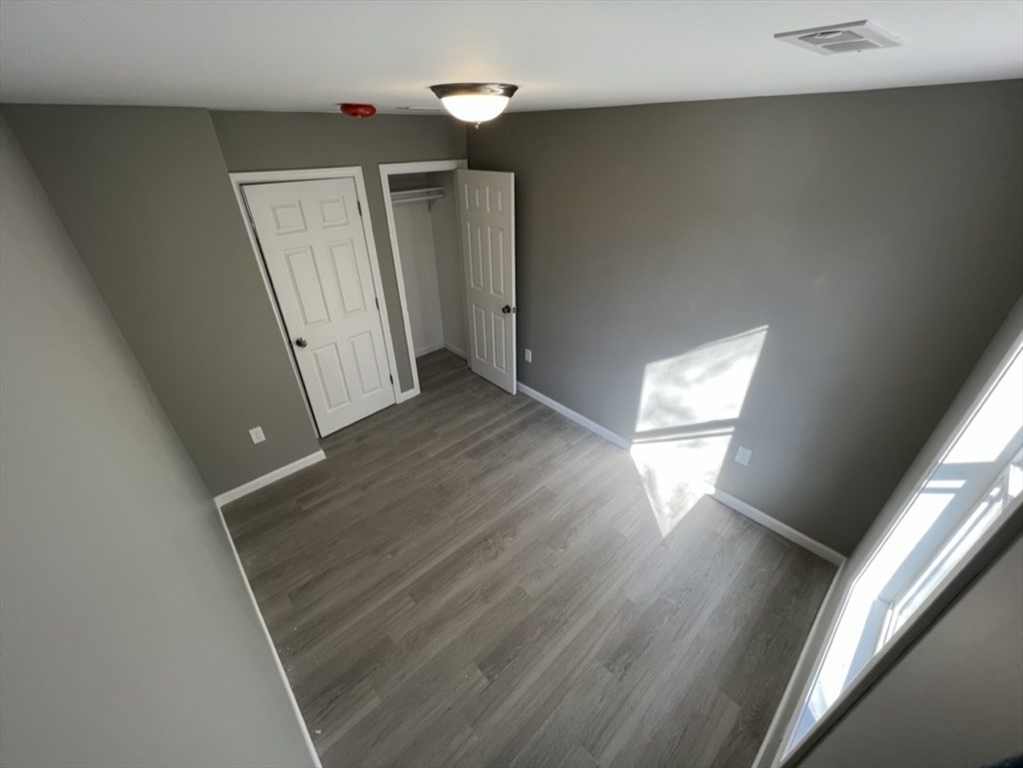 97 Alderman Street Springfield, MA 01108 - Photo 10 of 10 a view of empty room with wooden floor and fan