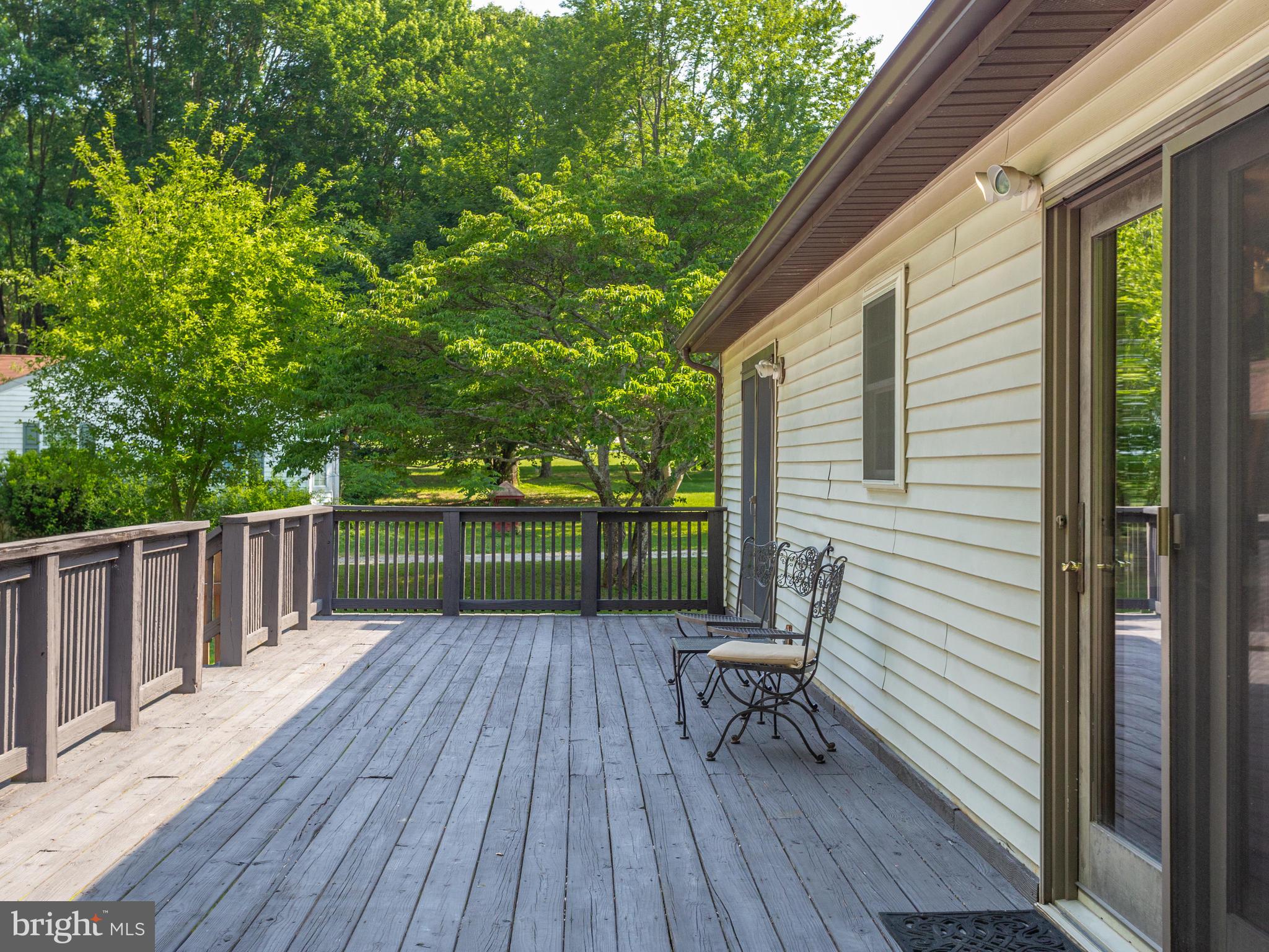 3100 Holland Cliffs Road Huntingtown, MD 20639 - Photo 19 of 44 a view of a chair and table on the wooden deck
