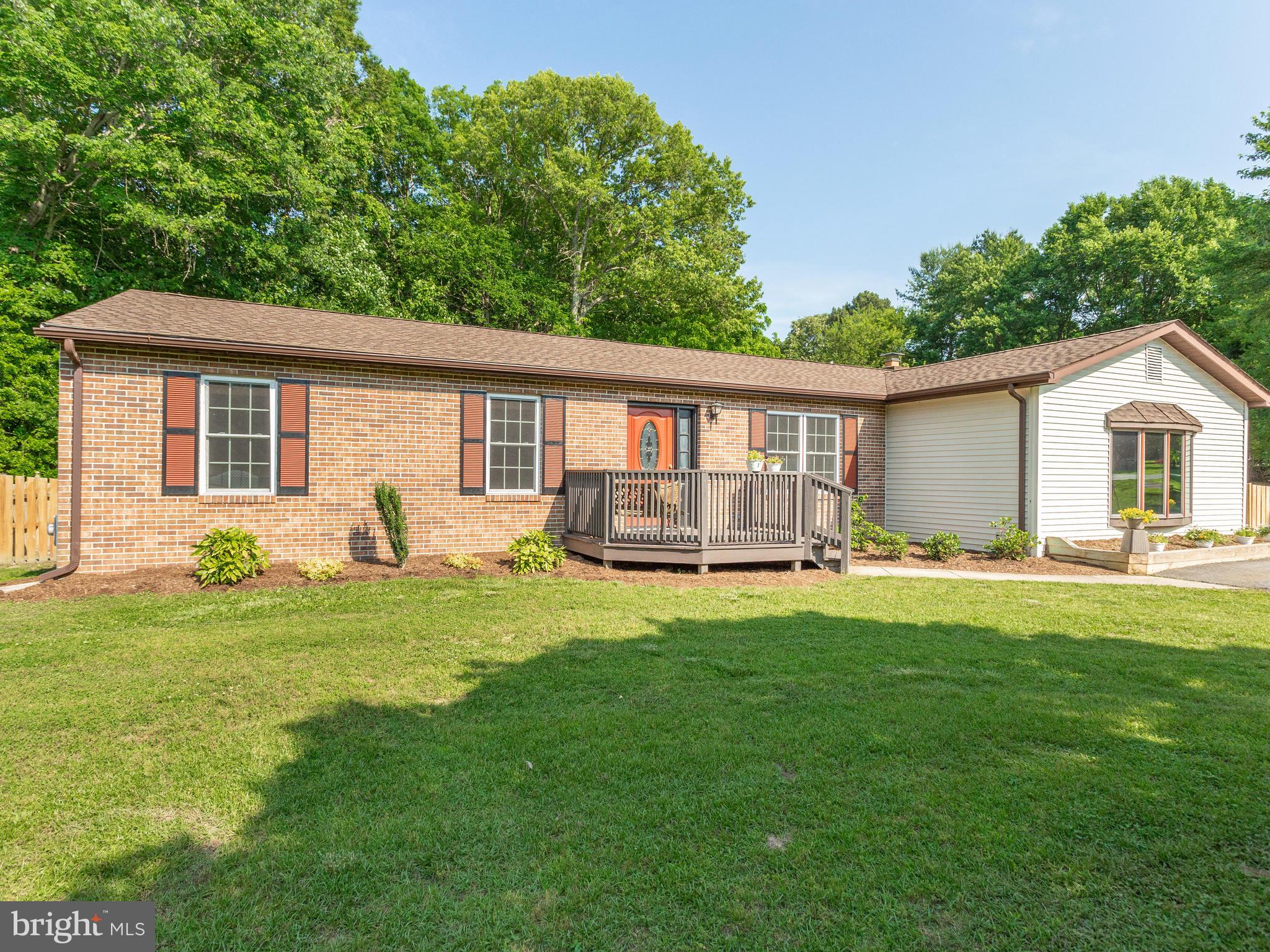 3100 Holland Cliffs Road Huntingtown, MD 20639 - Photo 3 of 44 a backyard of a house with table and chairs and potted plants with large tree