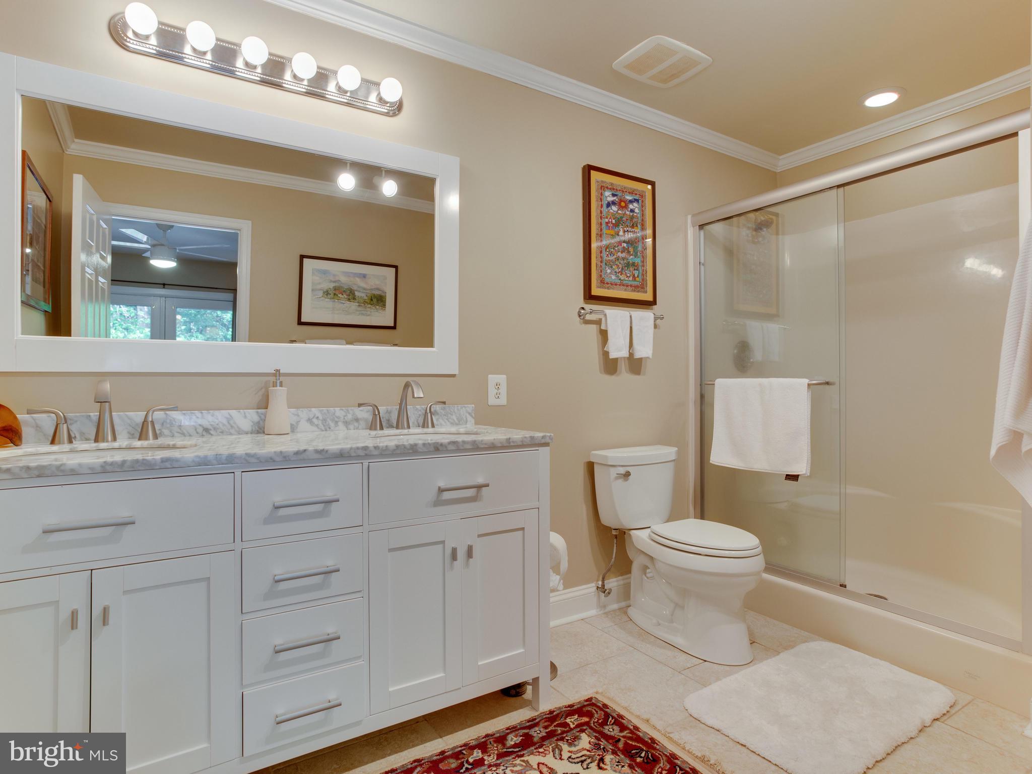 3100 Holland Cliffs Road Huntingtown, MD 20639 - Photo 23 of 44 a bathroom with a granite countertop toilet a sink a mirror a shower a vanity and window