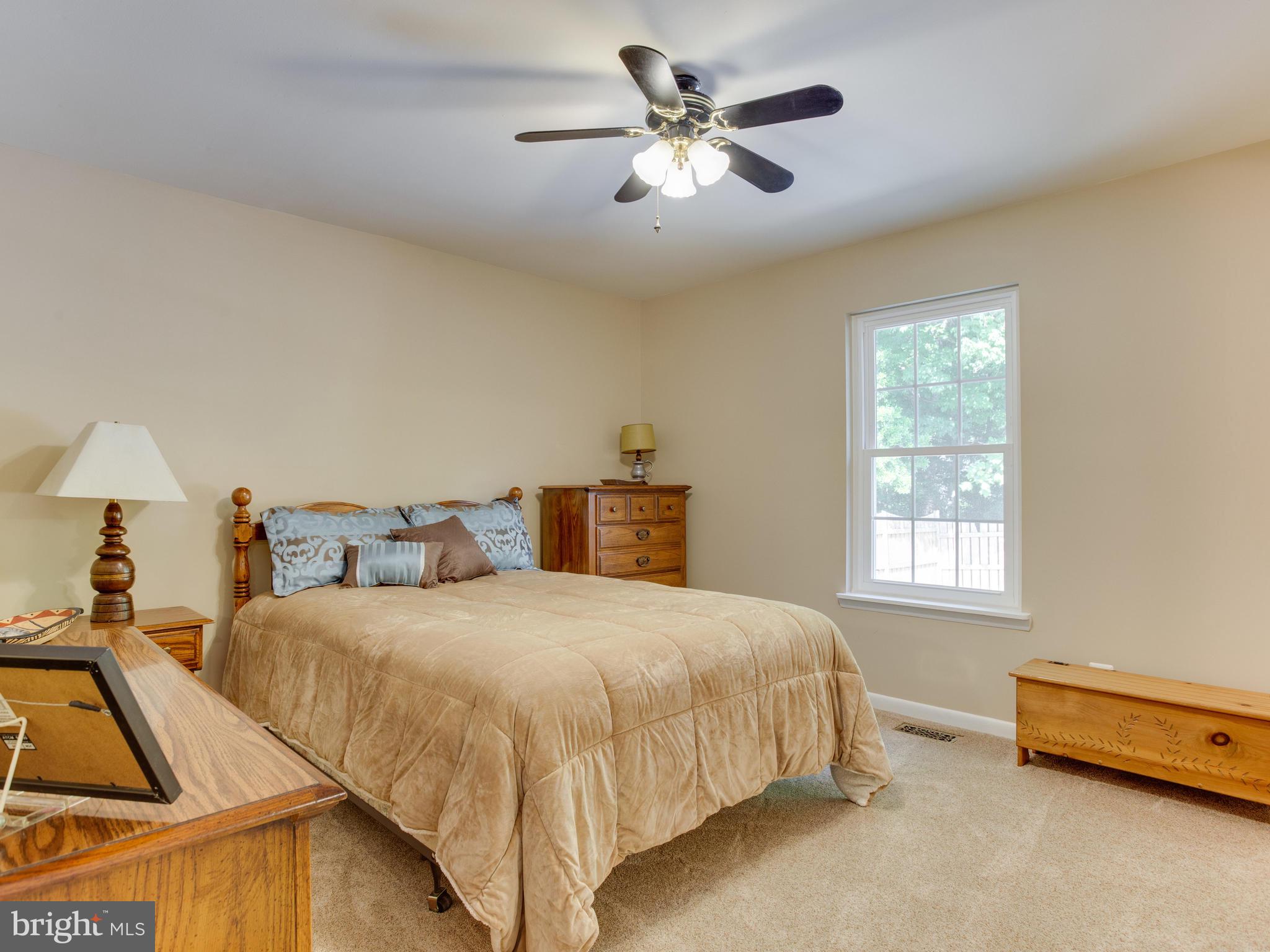 3100 Holland Cliffs Road Huntingtown, MD 20639 - Photo 26 of 44 a bedroom with a bed and a chandelier