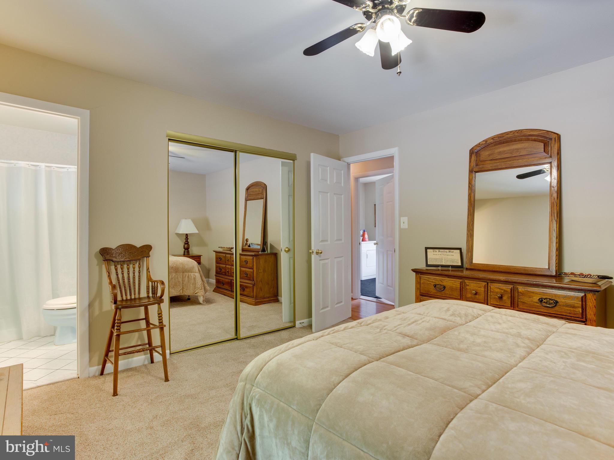 3100 Holland Cliffs Road Huntingtown, MD 20639 - Photo 27 of 44 a bedroom with a bed and a chandelier