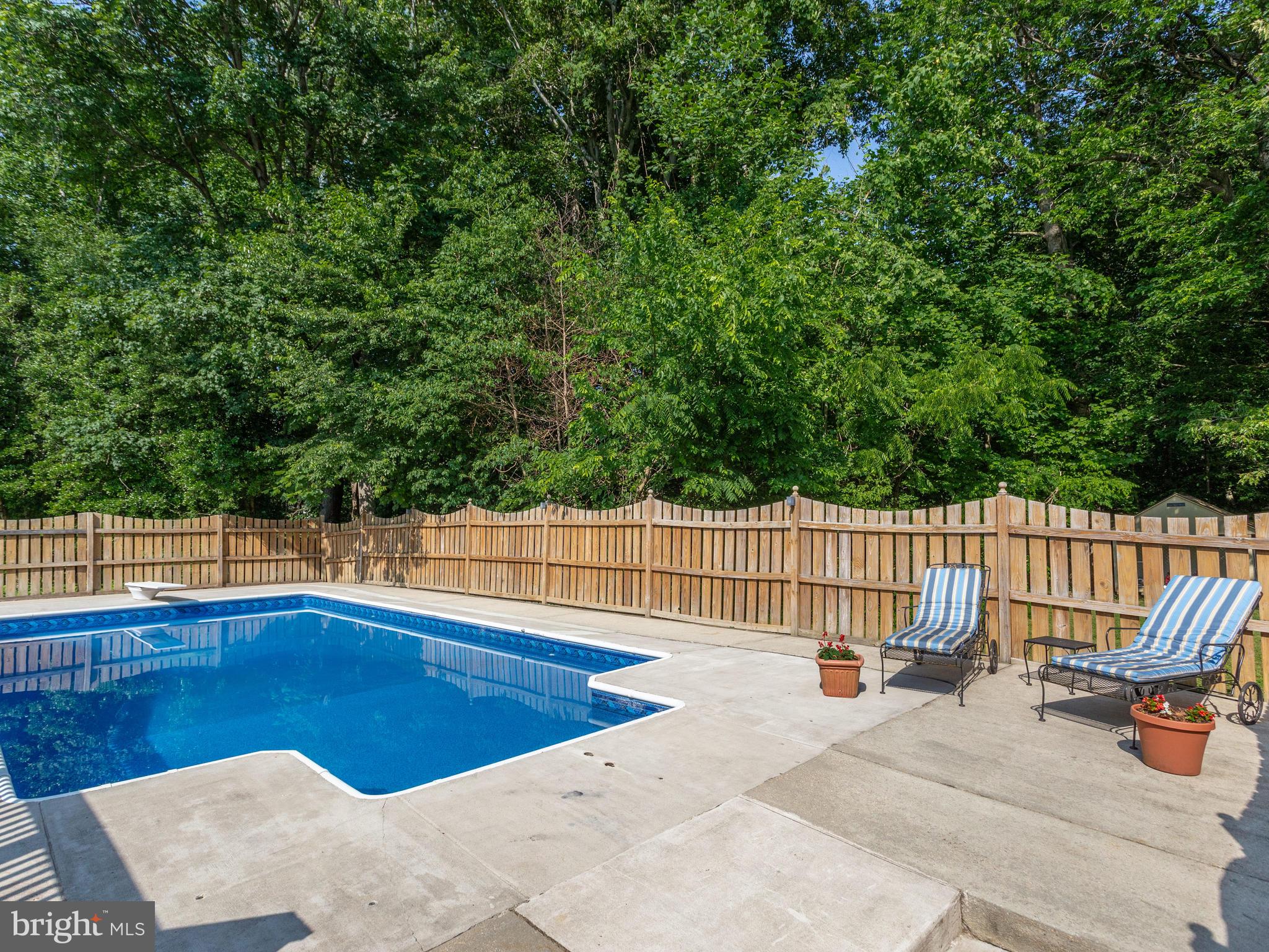 3100 Holland Cliffs Road Huntingtown, MD 20639 - Photo 33 of 44 a view of a swimming pool with a patio and wooden fence