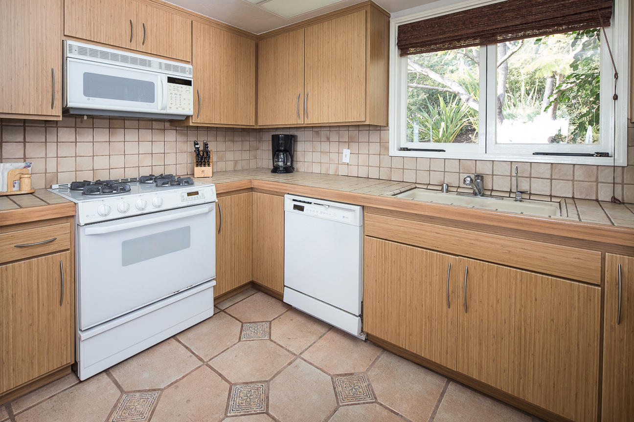 1213 Viscaino Road Santa Barbara, CA 93103 - Photo 12 of 22 a kitchen with white cabinets appliances a sink and a window