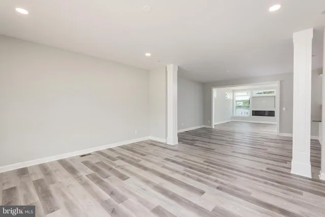 a view of empty room with wooden floor and windows