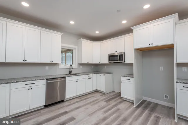 a kitchen with a sink window and cabinets