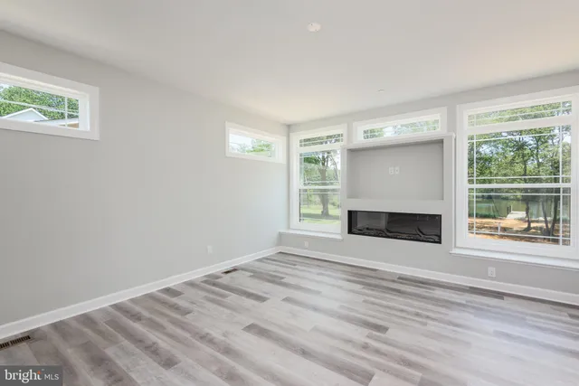 a view of an empty room with a window and a fireplace