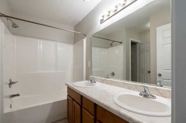 a bathroom with a granite countertop sink a mirror and a bathtub