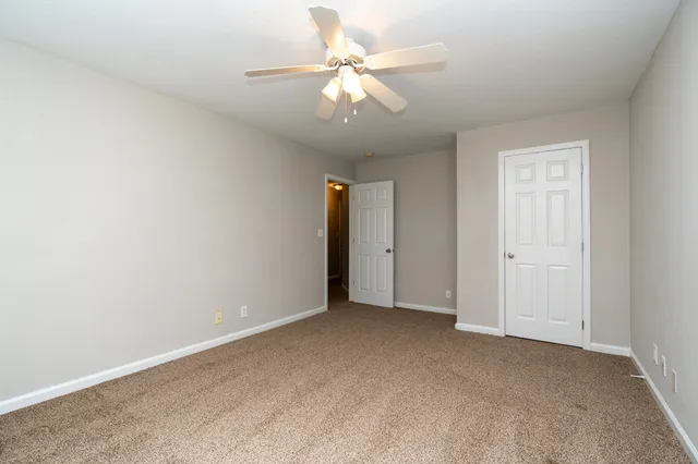 a view of an empty room with a ceiling fan