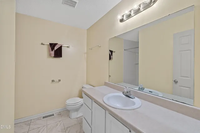 a kitchen with stainless steel appliances granite countertop a stove top oven a sink dishwasher and a refrigerator with wooden floor