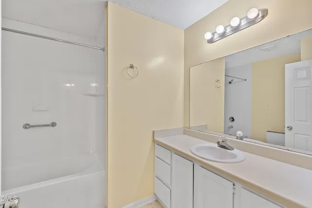 a bathroom with a granite countertop sink a toilet and a mirror