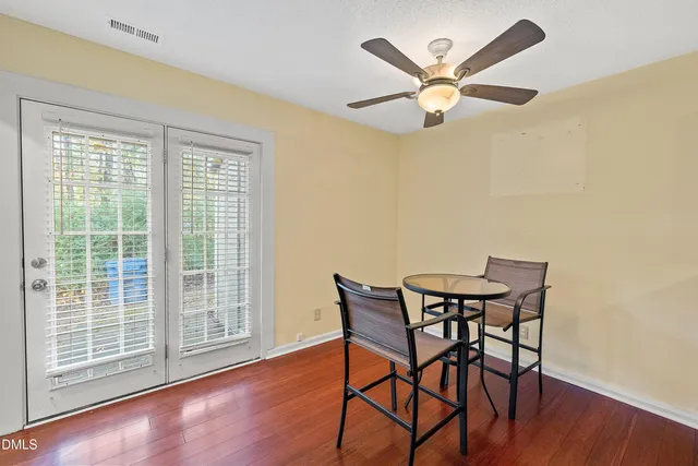 a view of a patio with couple of chairs and a barbeque