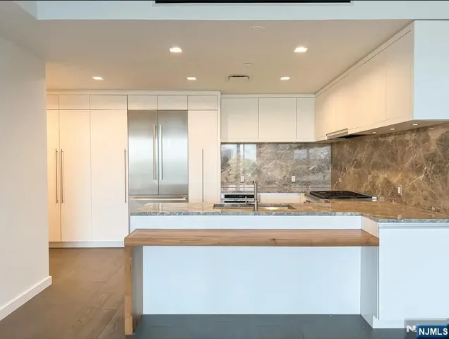 a view of kitchen with stainless steel appliances granite countertop refrigerator sink and stove