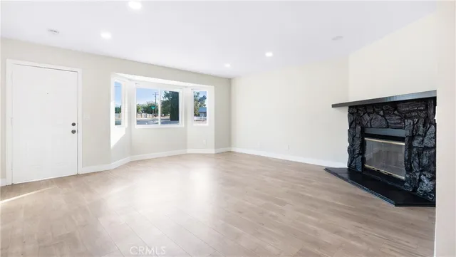 an empty room with windows and fireplace