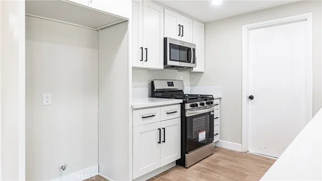 a kitchen with white cabinets and stainless steel appliances