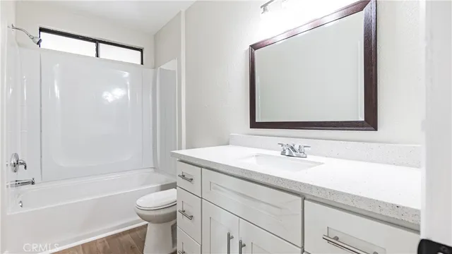 a bathroom with a sink a toilet and shower a mirror
