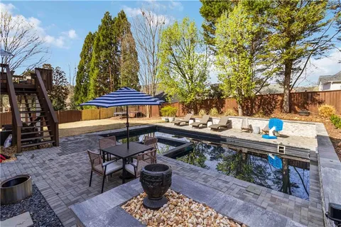 a backyard of a house with barbeque oven table and chairs