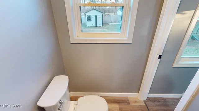 a white toilet sitting next to a window