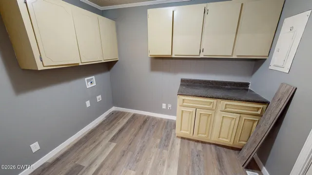 a kitchen with granite countertop white cabinets and a wooden floor
