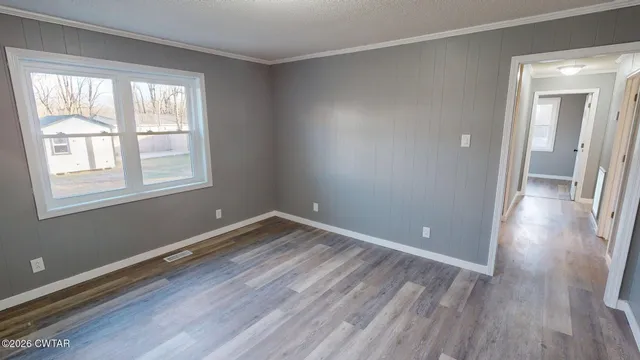a view of a room with wooden floor and windows