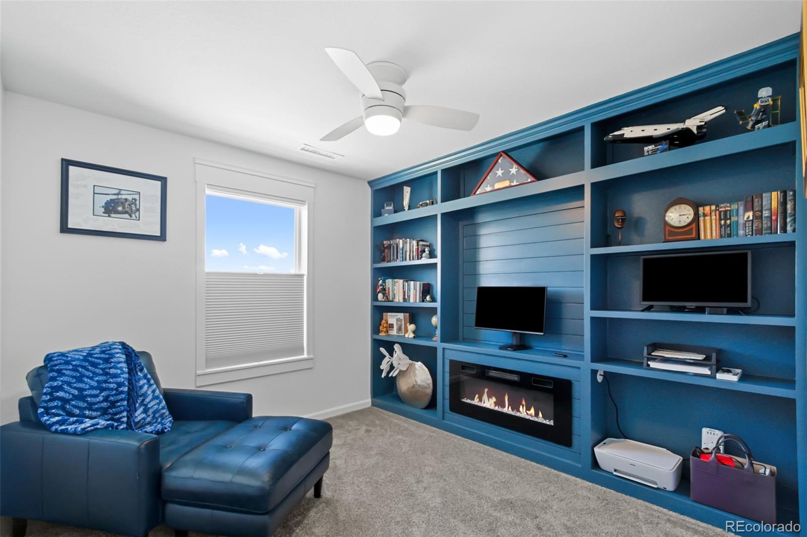9753 Middle Peak Street Littleton, CO 80125 - Photo 23 of 41 a living room with furniture and a flat screen tv