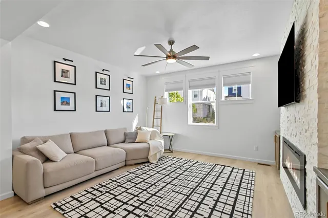 a living room with furniture and a dining table with chandelier