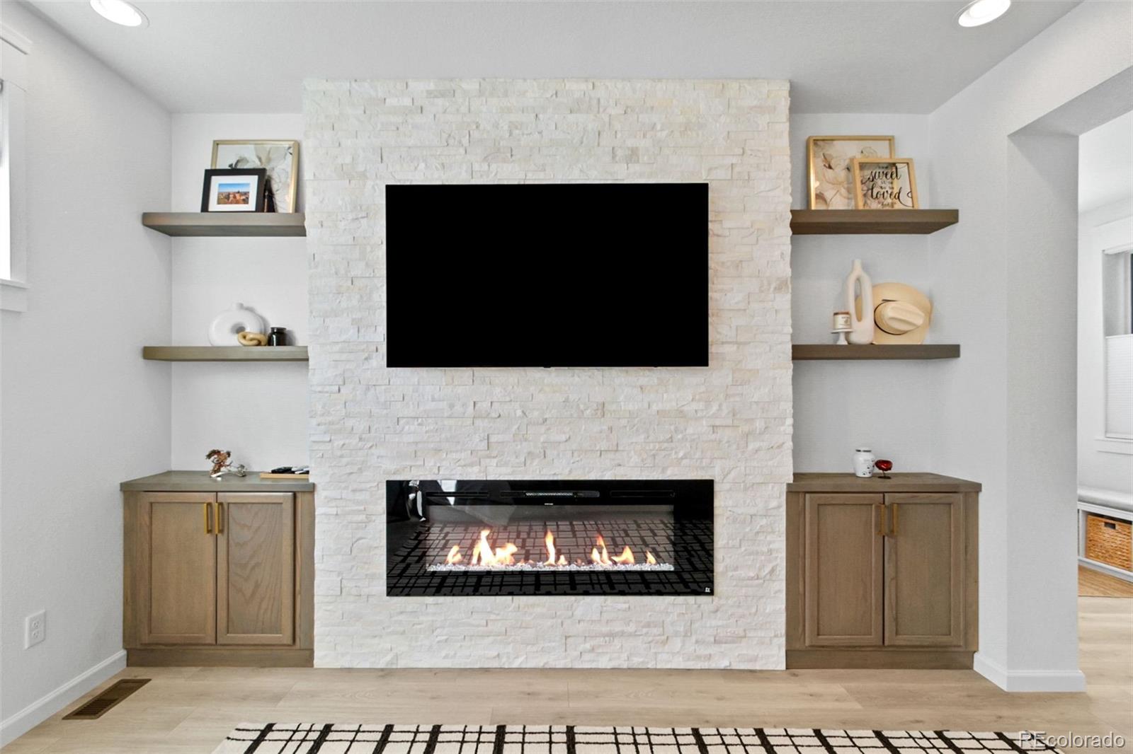 9753 Middle Peak Street Littleton, CO 80125 - Photo 7 of 41 a living room with a fireplace and a flat screen tv
