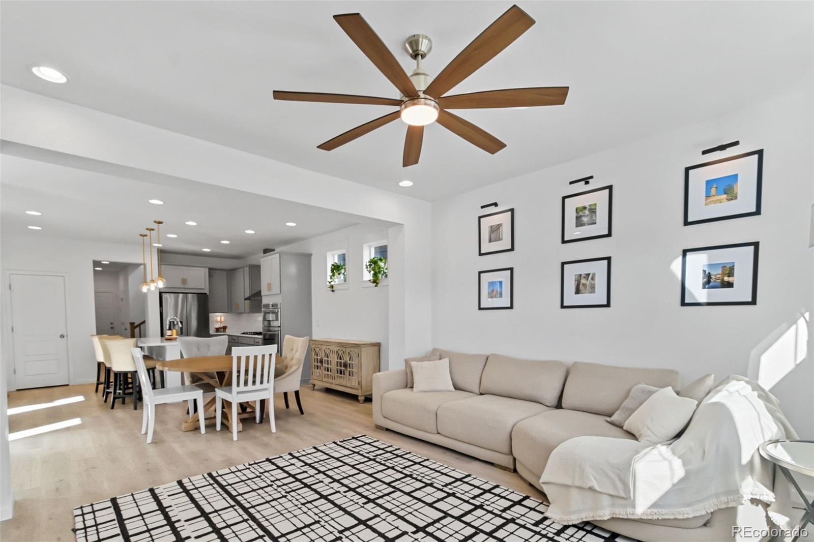 9753 Middle Peak Street Littleton, CO 80125 - Photo 8 of 41 a living room with furniture and a dining table with chandelier