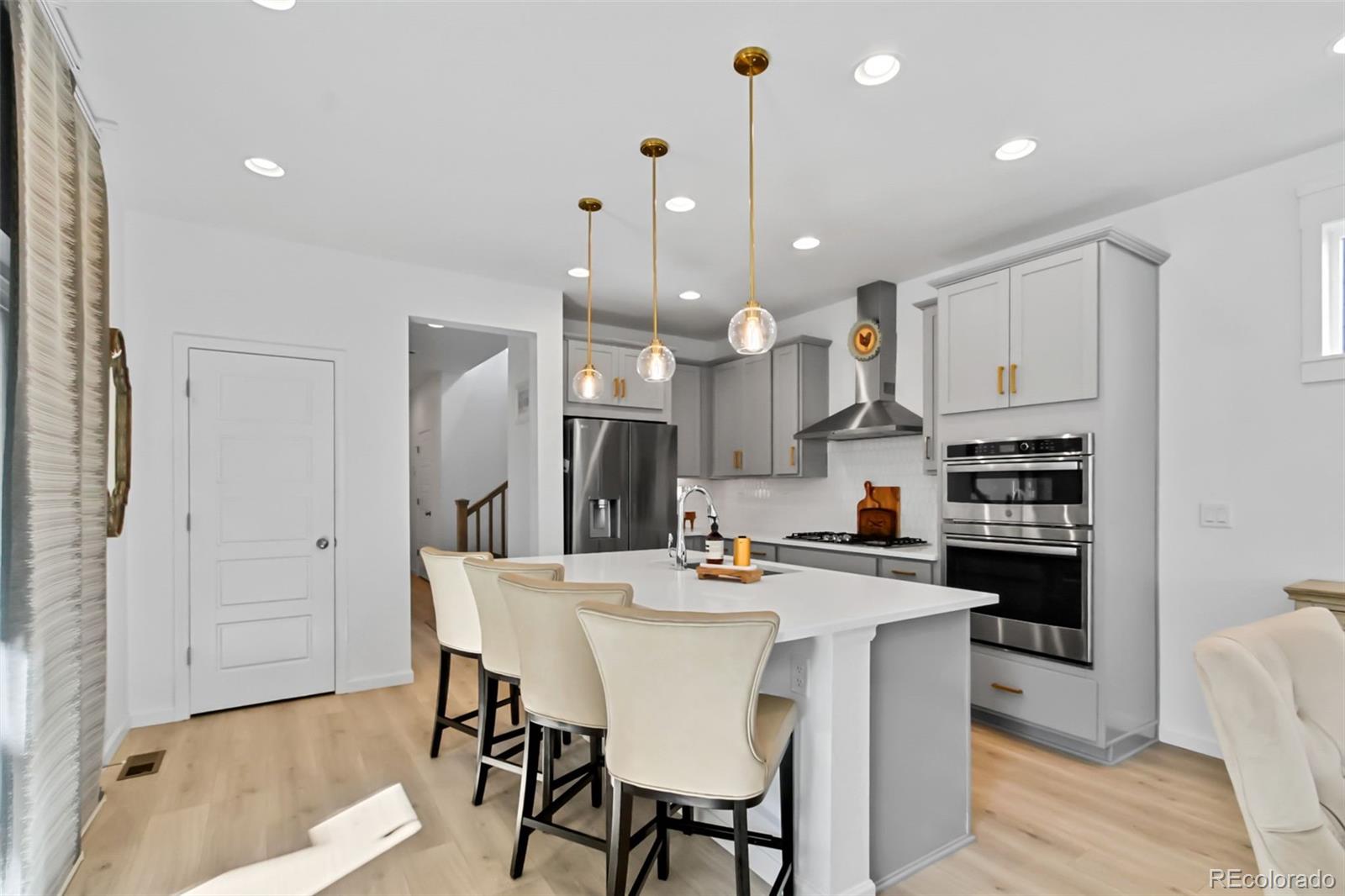 9753 Middle Peak Street Littleton, CO 80125 - Photo 9 of 41 a kitchen with stainless steel appliances kitchen island granite countertop a kitchen island a stove a table and chairs in it