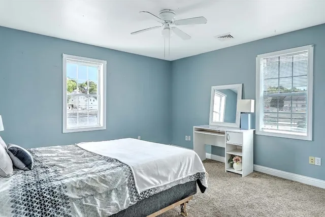 a bedroom with a large bed and a chandelier