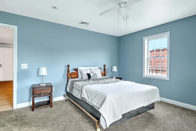 a bedroom with a bed a chandelier and a window