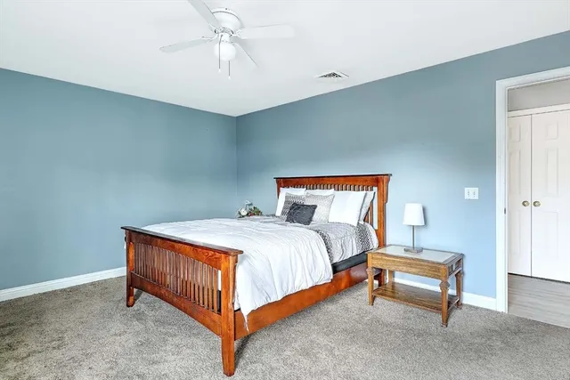 a bedroom with a bed and a chandelier fan