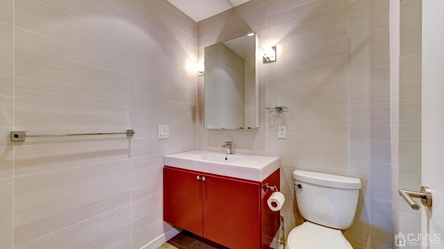 358 Rector Street, Unit 404 Perth Amboy, NJ 08861 - Photo 21 of 26 a bathroom with a toilet sink and mirror