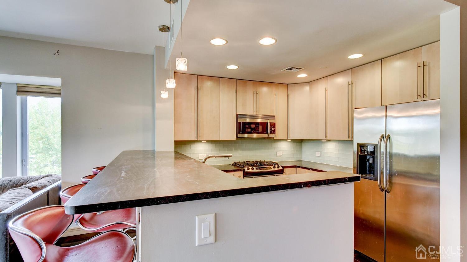 358 Rector Street, Unit 404 Perth Amboy, NJ 08861 - Photo 9 of 26 a kitchen with stainless steel appliances granite countertop a sink refrigerator and cabinets
