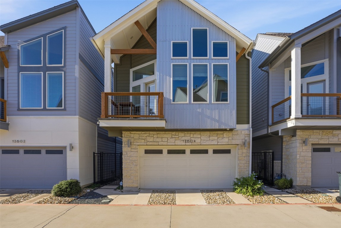 12604 Red Sparrow Street, Unit 14 Austin, TX 78729 - Photo 1 of 40 Contemporary home with a balcony, stone siding, concrete driveway, and a garage