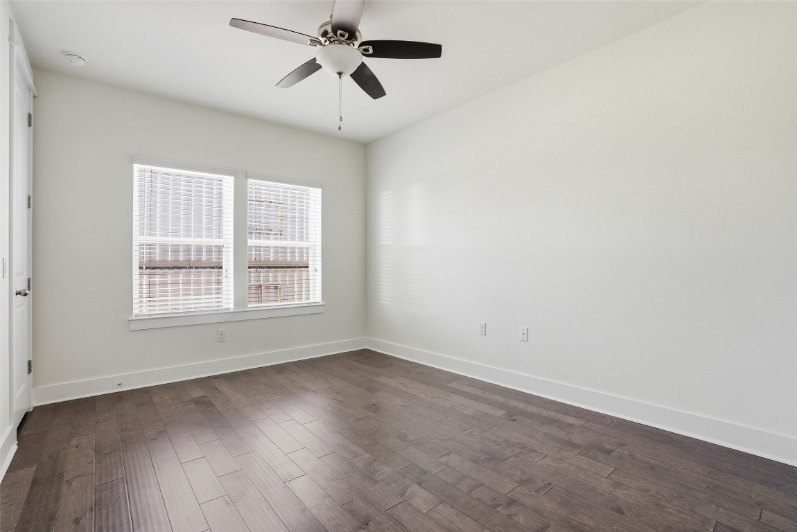 12604 Red Sparrow Street, Unit 14 Austin, TX 78729 - Photo 11 of 40 Spare room featuring dark wood-style floors and ceiling fan
