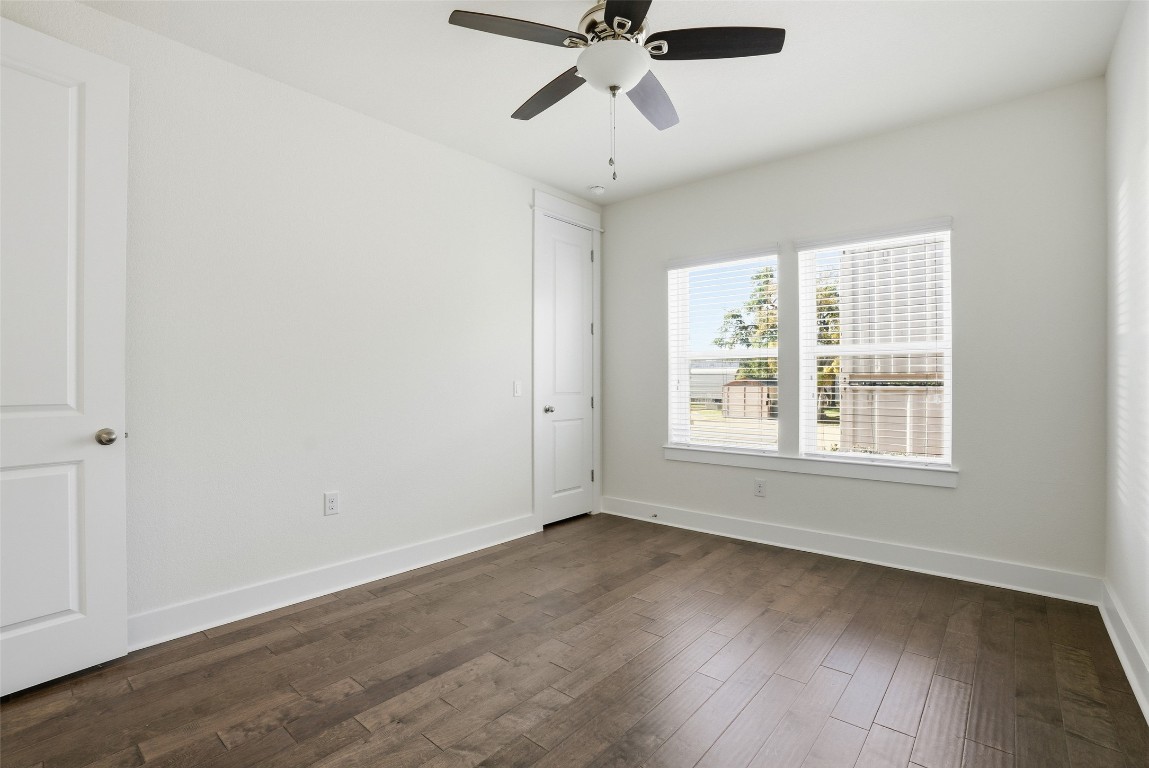 12604 Red Sparrow Street, Unit 14 Austin, TX 78729 - Photo 12 of 40 Unfurnished room with dark wood-style flooring and a ceiling fan