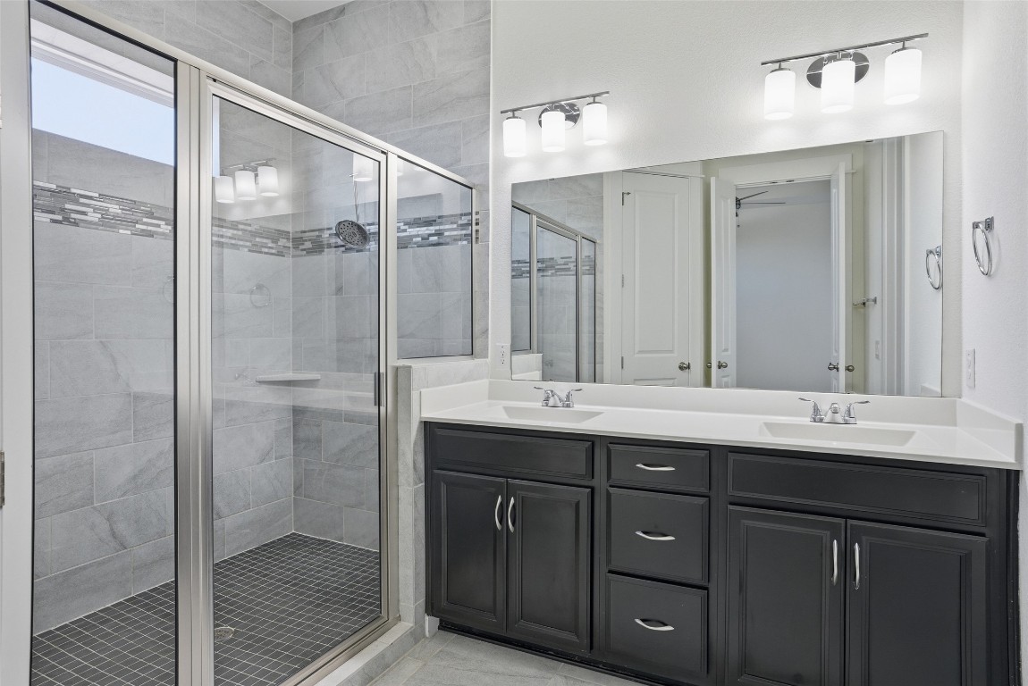 12604 Red Sparrow Street, Unit 14 Austin, TX 78729 - Photo 13 of 40 Bathroom with a stall shower and double vanity